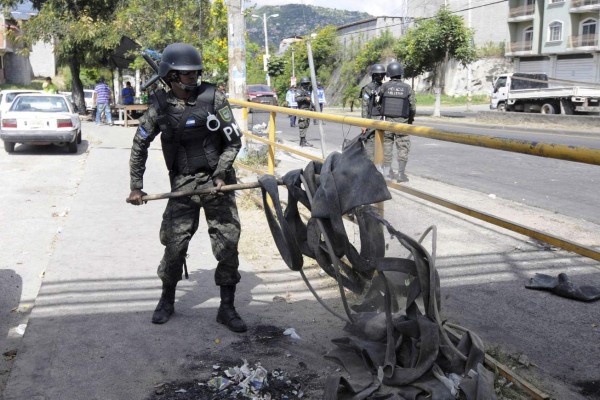 TEG6001. TEGUCIGALPA (HONDURAS), 02/12/2017.- Militares limpian los desechos de llantas quemadas que dejo las ultimas jornada de protestas hoy, sábado 2 de diciembre de 2017, en Tegucigalpa (Honduras). Honduras permanece hoy con la incertidumbre por la demora para conocer al nuevo presidente electo en los comicios del 26 de noviembre y un ambiente tenso tras la entrada en vigor en la medianoche del viernes de un estado de excepción que regirá durante 10 días. EFE/Humberto Espinoza