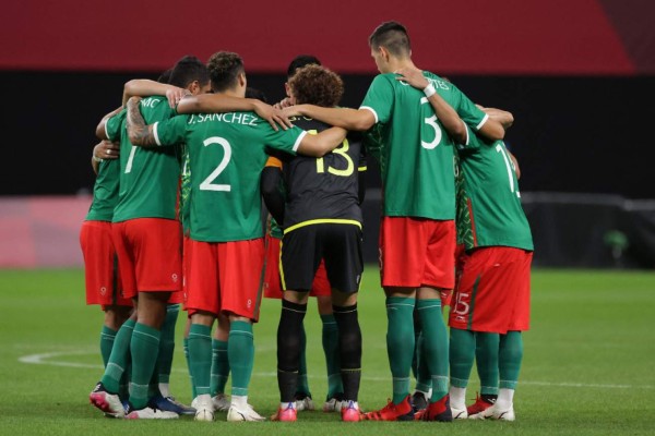 Mexico players gather in a huddle before the Tokyo 2020 Olympic Games men's group A first round football match between South Africa and Mexico at the Sapporo Dome in Sapporo on July 28, 2021. (Photo by ASANO IKKO / AFP)