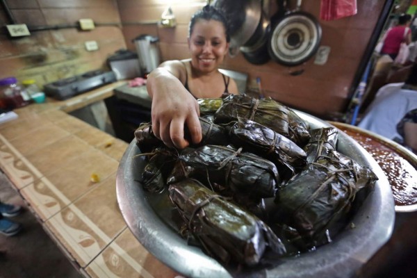 Una mujer vende nacatamales en un comedor este sábado en Tegucigalpa (Honduras). EFE