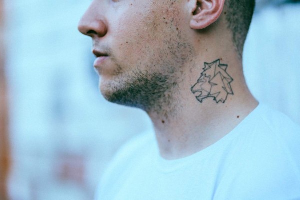 Vintage toned portrait image of a tattooed young man.