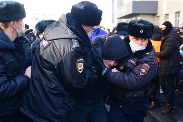 TOPSHOT - Police officers detain a man during a rally in support of jailed opposition leader Alexei Navalny in the far eastern city of Vladivostok on January 23, 2021. - Navalny, 44, was detained last Sunday upon returning to Moscow after five months in Germany recovering from a near-fatal poisoning with a nerve agent and later jailed for 30 days while awaiting trial for violating a suspended sentence he was handed in 2014. (Photo by Pavel KOROLYOV / AFP)