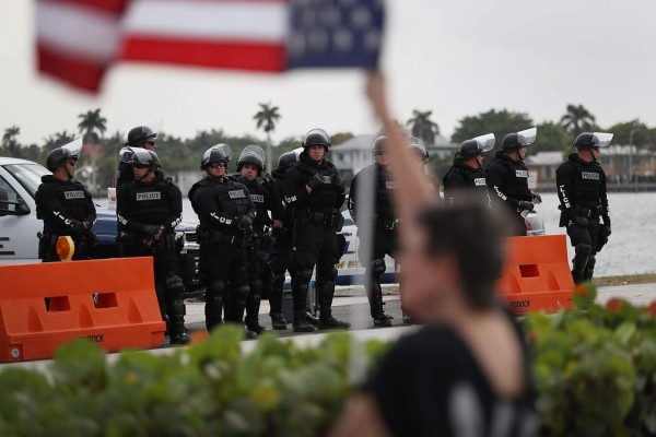 WEST PALM BEACH, FL - APRIL 06: Police stand by as protesters make themselves heard along the road-side as Chinese President Xi Jinping prepares to drive past in a convoy on his way to visit President Donald Trump at Mar-a-Lago April 6, 2017 in West Palm Beach, Florida. President Xi is in Florida to meet with President Donald Trump to discuss a range of sensitive issues including trade and North Korea. Joe Raedle/Getty Images/AFP== FOR NEWSPAPERS, INTERNET, TELCOS & TELEVISION USE ONLY ==