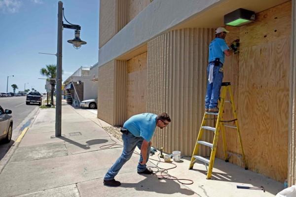 Workers board up the windows of a business in Flagler Beach, Florida, as they prepare for Hurricane Dorian, on August 31, 2019. - Hurricane Dorian changed course slightly on Saturday, possibly putting it on track to hit the Carolinas rather than Florida as previously forecast, after a dangerous blast through the Bahamas. Meteorologists said Dorian has grown into an extremely dangerous Category 4 storm as it heads toward land. (Photo by Ricardo ARDUENGO / AFP)