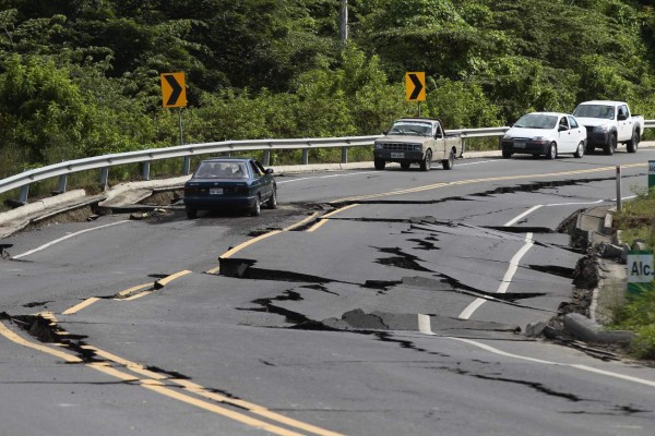 QUI02. COAQUE (ECUADOR) 18/04/2016.- Varios vehículos permanecen en la vía averiada hoy, lunes 18 de abril de 2016, en un fuerte sismo de 7,8 grados en Punto Palmar (Ecuador). El número de personas fallecidas a causa del terremoto que el pasado sábado azotó la zona tropical del norte de Ecuador se eleva a 413, según informó el Ministerio Coordinador de Seguridad en un comunicado. EFE/José Jácome