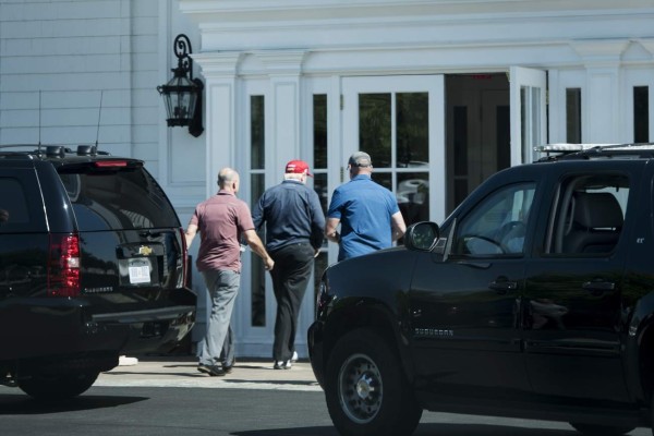 US President Donald Trump (C) arrives at the Trump National Golf Club May 14, 2017 in Sterling, Virginia. / AFP PHOTO / Brendan Smialowski