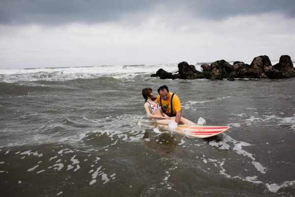 In this picture taken on June 14, 2017, 62-year-old Senji Nakajima tries to surf with his silicone sex doll Saori at Kujukuri beach, Chiba prefecture.Around 2,000 of the life-like dolls -- which cost around 6,000 USD and come with adjustable fingers, removable head and life-like genitals -- are sold each year in Japan, according to industry insiders. / AFP PHOTO / Behrouz MEHRI / TO GO WITH Japan-social-lifestyle,FEATURE by Alastair HIMMER
