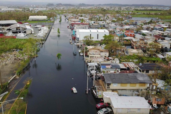 An aerial view shows the flooded neighbourhood of Juana Matos in the aftermath of Hurricane Maria in Catano, Puerto Rico, on September 22, 2017.Puerto Rico battled dangerous floods Friday after Hurricane Maria ravaged the island, as rescuers raced against time to reach residents trapped in their homes and the death toll climbed to 33. Puerto Rico Governor Ricardo Rossello called Maria the most devastating storm in a century after it destroyed the US territory's electricity and telecommunications infrastructure. / AFP PHOTO / Ricardo ARDUENGO