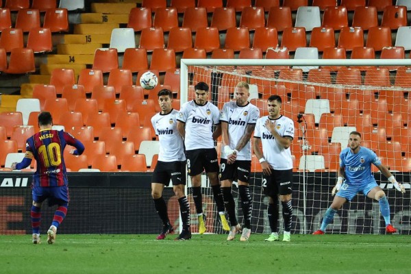 Barcelona's Argentinian forward Lionel Messi (L) scores his second goal during the Spanish League football match between Valencia and Barcelona at the Mestalla stadium in Valencia on May 2, 2021. (Photo by JOSE JORDAN / AFP)