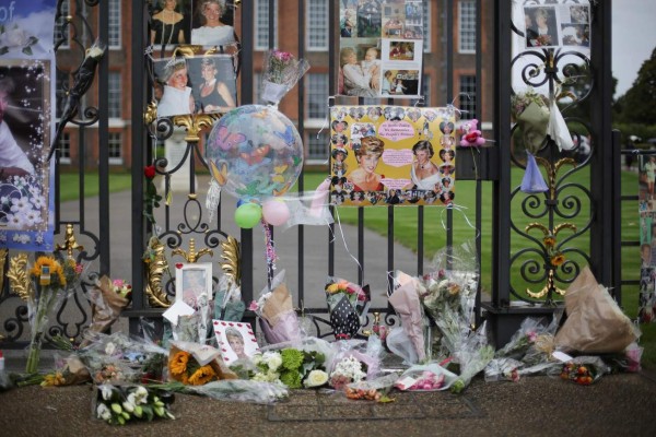 Floral tributes and photographs are seen outside one of the entrances of Kensington Palace to mark the coming 20th anniversary of the death of Diana, Princess of Wales, in London on August 30, 2017.Britain prepares to mark the 20th anniversary of the death of Diana, Princess of Wales. August 31, 1997, Britain's Diana, Princess of Wales, died in a high-speed car crash in Paris. For the week following, leading up to her spectacular funeral, Britain was plunged into an unprecedented outpouring of popular grief which shook the monarchy. / AFP PHOTO / DANIEL LEAL-OLIVAS