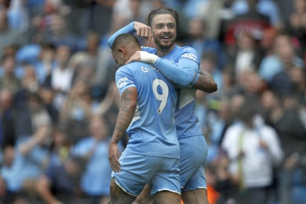 Manchester City's English midfielder Jack Grealish celebrates with Manchester City's Brazilian striker Gabriel Jesus (L) after scoring their second goal during the English Premier League football match between Manchester City and Norwich City at the Etihad Stadium in Manchester, north west England, on August 21, 2021. (Photo by Adrian DENNIS / AFP) / RESTRICTED TO EDITORIAL USE. No use with unauthorized audio, video, data, fixture lists, club/league logos or 'live' services. Online in-match use limited to 120 images. An additional 40 images may be used in extra time. No video emulation. Social media in-match use limited to 120 images. An additional 40 images may be used in extra time. No use in betting publications, games or single club/league/player publications. /