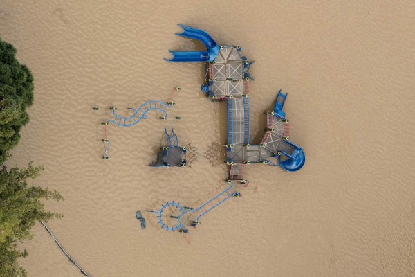 Floodwaters surround a play structure on February 22, 2017, in San Jose, California.Thousands of people were ordered to evacuate their homes early Wednesday in the northern California city of San Jose as floodwaters inundated neighborhoods and forced the shutdown of a major highway. / AFP PHOTO / NOAH BERGER