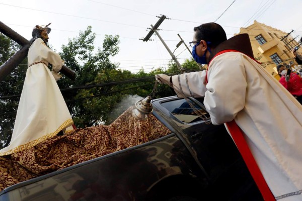 People go to the street to watch a procession this Good Friday in Tegucigalpa, Honduras, 10 April 2020. The Way of the Cross was commemorated with empty Catholic temples due to the coronavirus epidemic, while the traditional prcession was made with the images of Jesus Christ and the Virgin Mary in the back of two cars. EFE/Humberto Espinoza