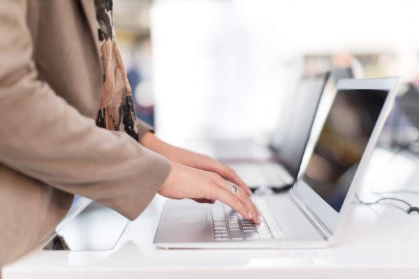 Unrecognizable woman typing on laptop