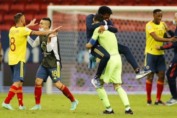 Colombia's goalkeeper David Ospina (R) celebrates with Colombia's Juan Cuadrado after defeating Uruguay in the penalty shootout of their Conmebol 2021 Copa America football tournament quarter-final match at the Mane Garrincha Stadium in Brasilia, Brazil, on July 3, 2021. (Photo by SILVIO AVILA / AFP)