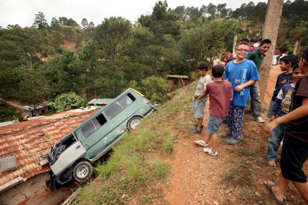 Microbús cae sobre el techo de una casa