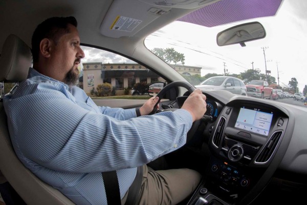Costa Rican Roberto Quiros, owner of two electric cars, charges one of them at a Costa Rican Institute of Electricity (ICE) charging station in San Jose on December 4, 2018. - Electric vehicles slowly gain space in Costa Rica's congested streets, a country that prides itself on being an ecological paradise and works on an agenda to decarbonize its economy. Despite the 600 electric cars in private hands seem like a drop of water in a vehicle fleet of around 1.4 million, experts foresee an exponential growth. (Photo by Ezequiel BECERRA / AFP)