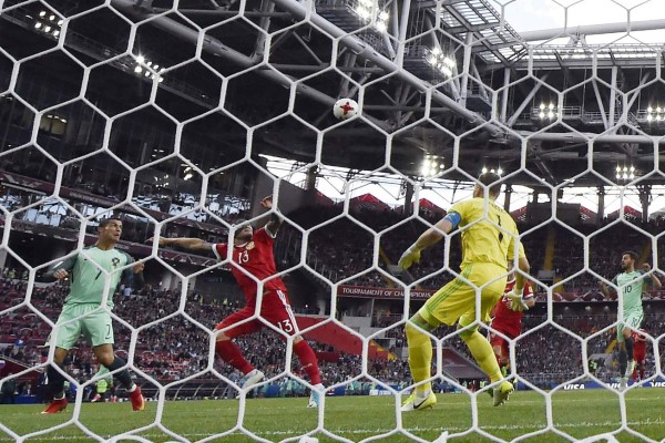 Portugal's forward Cristiano Ronaldo (L) heads the ball to score past Russia's goalkeeper Igor Akinfeev (R) during the 2017 Confederations Cup group A football match between Russia and Portugal at the Spartak Stadium in Moscow on June 21, 2017. / AFP PHOTO / Alexander NEMENOV