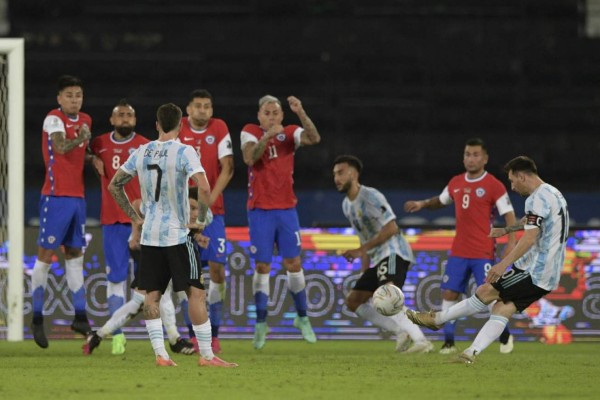 Argentina's Lionel Messi (R) takes a free-kick to score against Chile during their Conmebol Copa America 2021 football tournament group phase match at the Nilton Santos Stadium in Rio de Janeiro, Brazil, on June 14, 2021. (Photo by CARL DE SOUZA / AFP)