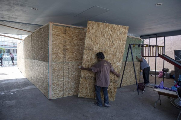 Workers set wooden walls to build a new room for the migrants at Madre Assunta Institute, a shelter for migrant women and children in Tijuana, Baja California state, Mexico on July 13, 2019. - Asylum seekers in the US are overflowing shelters in Mexico waiting for their claims to be processed. (Photo by Eduardo Jaramillo Castro / AFP)