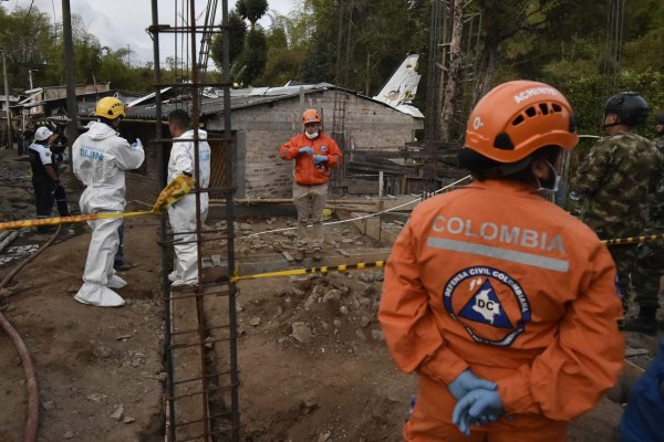 Rescuers work at the site where a plane crashed at the Junin neighborhood in Popayan, southwestern Colombia, on September 15, 2019. - At least seven people were killed and another three injured when a small plane crashed in southwestern Colombia on Sunday, a firefighter said. (Photo by LUIS ROBAYO / AFP)