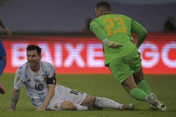 Argentina's Lionel Messi looks on from the ground after slipping next to Brazil's goalkeeper Ederson during the Conmebol 2021 Copa America football tournament final match against Brazil at the Maracana Stadium in Rio de Janeiro, Brazil, on July 10, 2021. (Photo by CARL DE SOUZA / AFP)