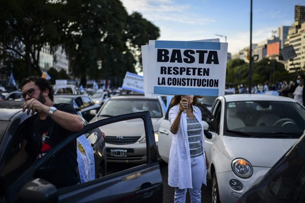 A woman holds a banner reading 'Enough. Respect the Constitution' as she takes part in a protest against Argentine President Alberto Fernandez and the new restrictions to mitigate the spread of the novel coronavirus, at 9 de Julio Avenue in Buenos Aires, on April 17, 2021. - Several points of the Argentine capital were the scene of protests on Saturday against the restrictions launched by the government until the end of April to mitigate the spread of the coronavirus, which has accelerated in recent weeks, with more than 2.6 million cases and 59,000 deaths. (Photo by Ronaldo SCHEMIDT / AFP)