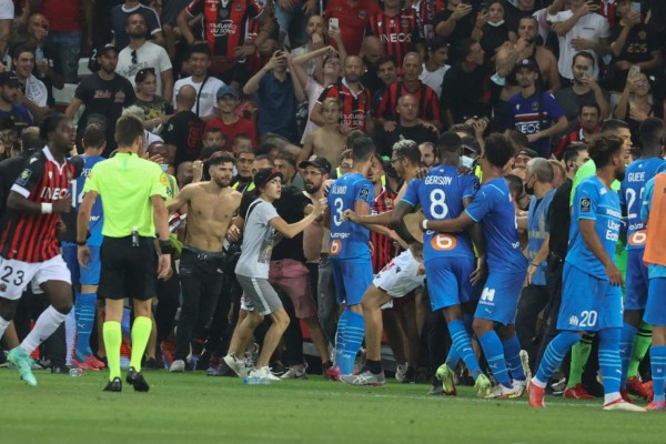 Fans invade the pitch during the French L1 football match between OGC Nice and Olympique de Marseille (OM) at the Allianz Riviera stadium in Nice, southern France on August 22, 2021. (Photo by Valery HACHE / AFP)