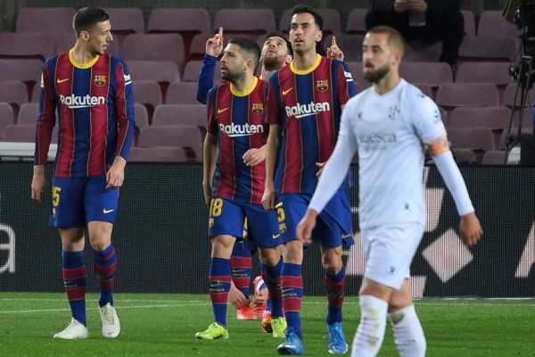 Barcelona's Argentinian forward Lionel Messi (C) celebrates with teammates after scoring a goal during the Spanish League football match between Barcelona and SD Huesca at the Camp Nou stadium in Barcelona on March 15, 2021. (Photo by LLUIS GENE / AFP)