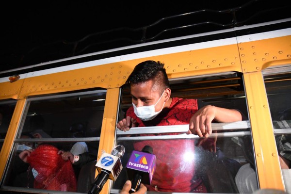 A migrant, part of a group of 71 Guatemalans deported from the United States, wears a face mask as a preventive measure against the novel coronavirus COVID-19, as he speaks with journalists from a bus, after landing at the Air Force base in Guatemala City on May 11, 2020. - Guatemalan immigration authorities confirmed on Monday that in the last two months it received 102 deported migrants infected with the novel coronavirus, COVID-19, from the United States. (Photo by Johan ORDONEZ / AFP)