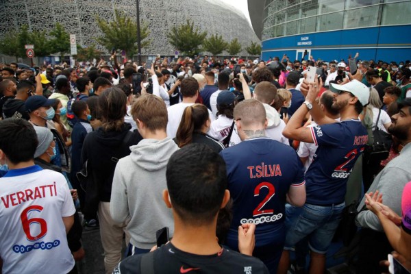 People gather outside the Parc des Princes stadium in Paris as Argentinian football player Lionel Messi is expected to arrive on August 9, 2021, a day after the 34-year-old told at his tearful farewell news conference in Barcelona that joining French football club Paris Saint-Germain was a 'possibility. (Photo by Zakaria ABDELKAFI / AFP)