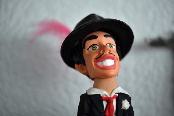 Picture of a toy figure representing Mexican actor known as 'Tin Tan,' who was a Pachuco- the subculture that characterized Mexican gangs set up in the United States in the 1940s - taken at the hosue of a Pachuco in Mexico City's Tepito neighbourhood on August 22, 2017.Wearing their feathered hats, colorful tank tops, gold chains on the lapel and patent leather shoes, the Pachucos continue to dance to the rhythm of legendary mambo Salons in Mexico. / AFP PHOTO / Yuri CORTEZ / TO GO WITH AFP STORY by YEMELI ORTEGA