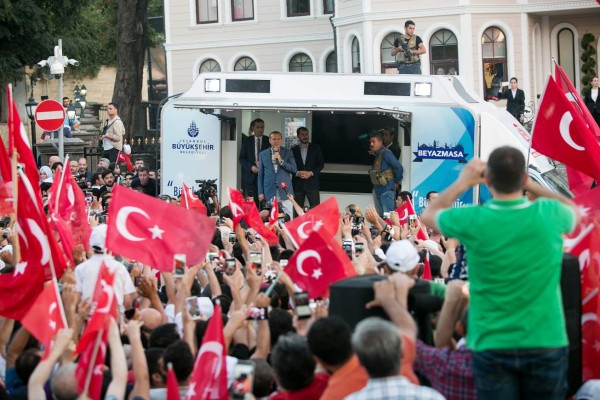 Turkish President Recep Tayyip Erdodan (C, L) speaks during a rally near his house in Istanbul on July 16, 2016 after Turkish authorities wrested back control of the Ataturk airport. President Recep Tayyip Erdogan urged Turks to remain on the streets on July 16, 2016, as his forces regained control after a spectacular coup bid by discontented soldiers that claimed more than 250 lives. Describing the attempted coup as a 'black stain' on Turkey's democracy, Yildirim said that 161 people had been killed in the night of violence and 1,440 wounded. / AFP PHOTO / GURCAN OZTURK