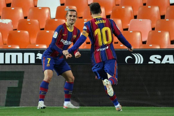 Barcelona's French midfielder Antoine Griezmann (L) celebrates scoring his team's second goal during the Spanish League football match between Valencia and Barcelona at the Mestalla stadium in Valencia on May 2, 2021. (Photo by JOSE JORDAN / AFP)