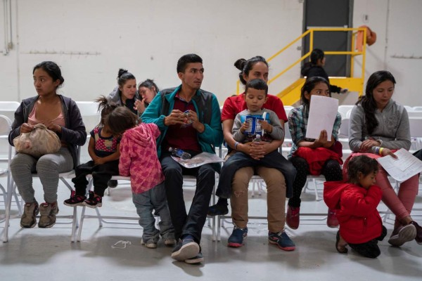 Migrants from Honduras and other countries wait to make phone calls and travel arrangements to their family in friends who host them in the United States at the Casa del Refugiado, or The House of Refugee, a new centre opened by the Annunciation House to help the large flow of migrants being released by the United States Border Patrol and Immigration and Customs Enforcement in El Paso, Texas on April 24, 2019. - The 125,000 foot space will accomodate about 500 migrants, with plans to expand for up to 1,500. While this is larger then other centres in the El Paso area, Father Ruben Garcia the director of Annunciation house says that they will still rely on churches around the community for help housing migrants. According to the CBP, border patrol agents apprehended 92,607 people along the southwest border in March, up from 66,884 in February. US President Donald Trump, who has made immigration the core of his message to his conservative base, said on Twitter that 'a very big Caravan of over 20,000 people' is making its way through Mexico toward the United States. (Photo by Paul Ratje / AFP)