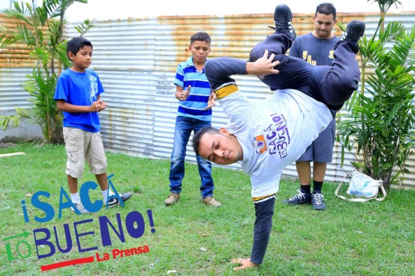 Kelvin Enamorado muestra su habilidad en el baile, mientras lo observan su hermano Juan Carlos y dos menores que se entrenan en la organización Warrios Crew del sector Chamelecón. Foto: Franklyn Muñoz