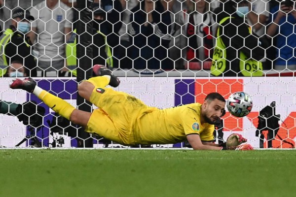 Italy's goalkeeper Gianluigi Donnarumma saves a decisive penalty by England's midfielder Bukayo Saka in the shootout during the UEFA EURO 2020 final football match between Italy and England at the Wembley Stadium in London on July 11, 2021. (Photo by Paul ELLIS / POOL / AFP)
