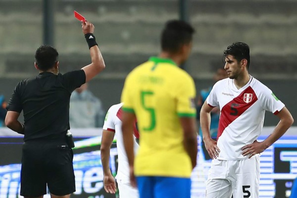 Chilean referee Julio Bascunan expels Peru's Carlos Zambrano for hitting Brazil's Richarlison with an elbow on the face, during the 2022 FIFA World Cup South American qualifier football match between Peru and Brazil at the National Stadium in Lima, on October 13, 2020, amid the COVID-19 novel coronavirus pandemic. (Photo by Daniel APUY / POOL / AFP)