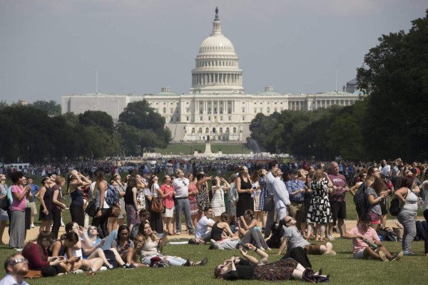 MRX17. WASHINGTON (EE.UU.), 21/08/2017.- Personas observan el eclipse solar desde el National Mall, en Washington D.C., (Estados Unidos) hoy, lunes 21 de agosto de 2017. El acontecimiento tardó una hora y media en recorrer el cielo desde la costa del Pacífico, donde comenzó a las 10.15 hora local (17.15 GMT), a la del Atlántico, donde acabó en torno a las 14.45 hora local (18.45 GMT). EFE/MICHAEL REYNOLDS