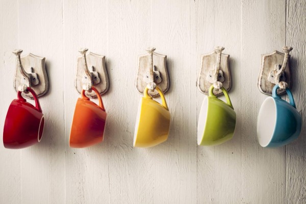 Colorful coffee cups on hooks