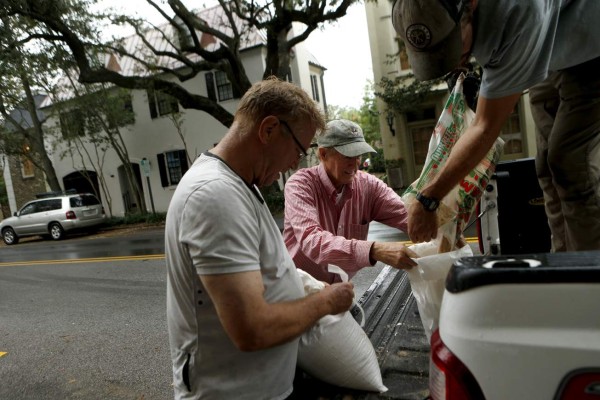 Residentes de las Carolinas se preparan ante los posibles efectos del huracán Matthew, como estas personas de las ciudad de Charleston, que llenan sacos de arena ante posibles inundaciones. Foto: AFP