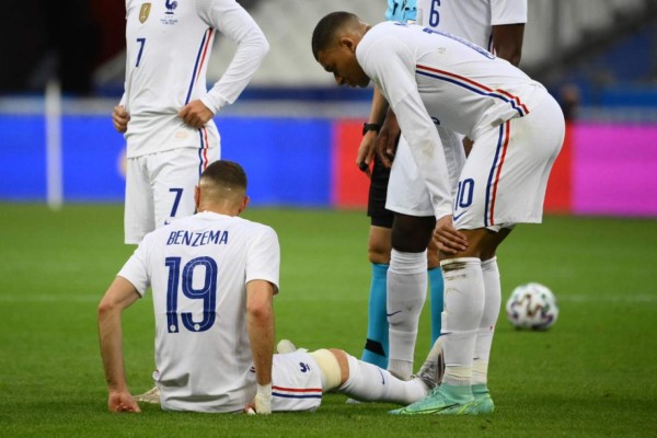 France's forward Kylian Mbappe (R) looks at France's forward Karim Benzema, injured, during the friendly football match France vs Bulgaria ahead of the Euro 2020 tournament, at Stade De France in Saint-Denis, on the outskirts of Paris on June 8, 2021. (Photo by FRANCK FIFE / AFP)