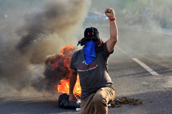 TOPSHOT - Students of the National Autonomous University of Honduras (UNAH) block a road in Tegucigalpa on June 19, 2019 during a protest against the government of Honduran President Juan Orlando Hernandez for measures they say will privatize health and education services. (Photo by ORLANDO SIERRA / AFP)
