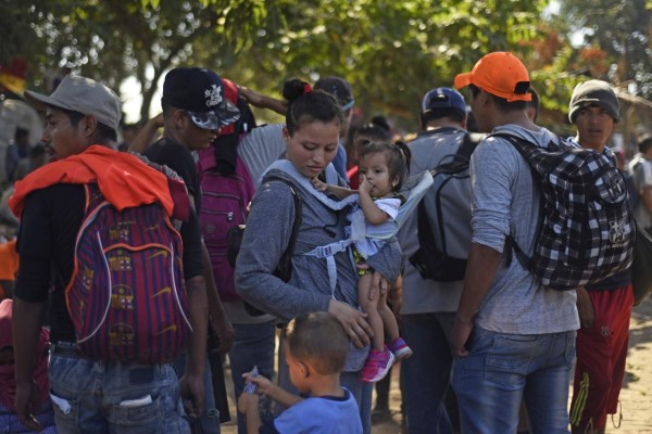 Central American migrants -mostly Hondurans heading in a caravan for the US- remain on the bank of the Suchiate river, where they spent the night, in Tecun Uman, Guatemala, on the border with Ciudad Hidalgo, Mexico, on January 21, 2020. - Some 500 Central Americans, from the so-called '2020 Caravan', crossed Monday from Guatemala to Mexico, but over 400 were intercepted when National Guardsmen fired tear gas at them. (Photo by Johan ORDONEZ / AFP)
