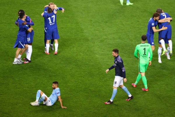 Manchester City's Algerian midfielder Riyad Mahrez (L) reacts to the loss as Chelsea's players celebrate the win in the UEFA Champions League final football match between Manchester City and Chelsea at the Dragao stadium in Porto on May 29, 2021. (Photo by MICHAEL STEELE / POOL / AFP)