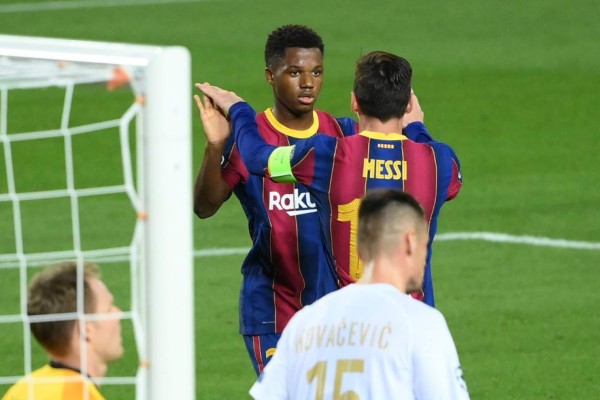 Barcelona's Spanish forward Ansu Fati (C) celebrates with Barcelona's Argentine forward Lionel Messi after scoring a goal during the UEFA Champions League football match between FC Barcelona and Ferencvarosi TC at the Camp Nou stadium in Barcelona on October 20, 2020. (Photo by LLUIS GENE / AFP)