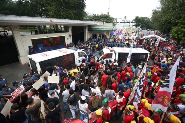 Una patrulla de la policía trató de reprimir a un grupo de manifestantes frente a la embaja de EUA en Manila.