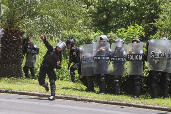 Nicaragua's riot police throw tear gas towards anti-government protestors outside the Managua Cathedral after a mass to celebrate the release of political prisoners, in Managua on June 16, 2019. (Photo by Maynor Valenzuela / AFP)