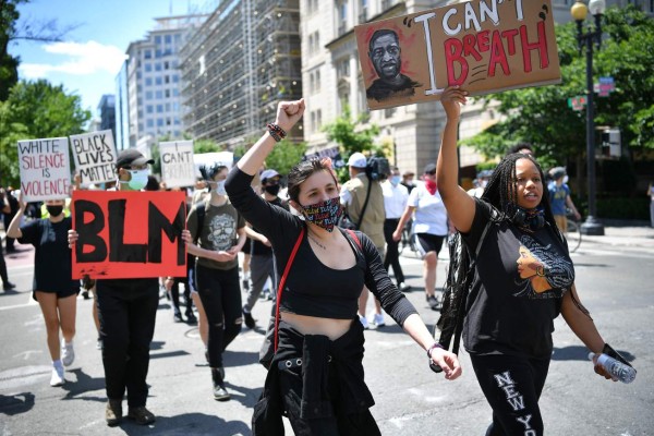 People protest the death of George Floyd, an unarmed black man who died while while being arrested and pinned to the ground by the knee of a Minneapolis police officer,down the street from the White House in Washington, DC on June 1, 2020. - Police fired tear gas outside the White House late Sunday as anti-racism protestors again took to the streets to voice fury at police brutality, and major US cities were put under curfew to suppress rioting.With the Trump administration branding instigators of six nights of rioting as domestic terrorists, there were more confrontations between protestors and police and fresh outbreaks of looting. Local US leaders appealed to citizens to give constructive outlet to their rage over the death of an unarmed black man in Minneapolis, while night-time curfews were imposed in cities including Washington, Los Angeles and Houston. (Photo by MANDEL NGAN / AFP)