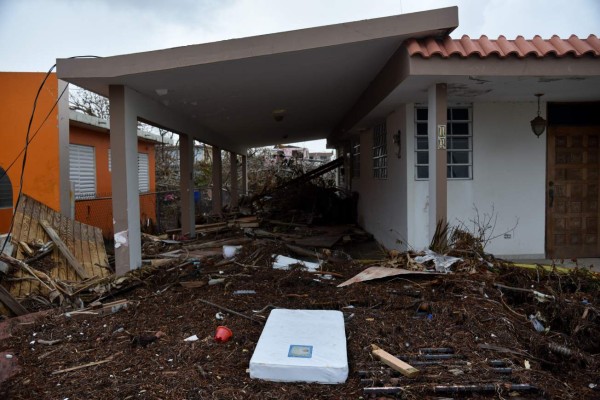 A mattress is seen in front of a house in Punta Santiago, Humacao, in the east of Puerto Rico, on September 27, 2017, one week after the passage of Hurricane Maria. The US island territory, working without electricity, is struggling to dig out and clean up from its disastrous brush with the hurricane, blamed for at least 33 deaths across the Caribbean. / AFP PHOTO / HECTOR RETAMAL