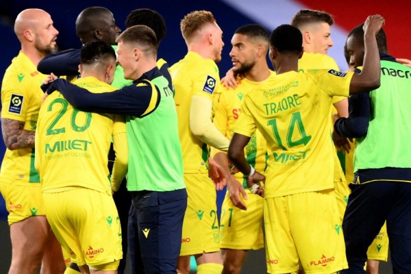 Nantes players celebrate after winning the French L1 football match between PSG and Nantes at the Parc des Princes stadium in Paris on March 14, 2021. (Photo by FRANCK FIFE / AFP)